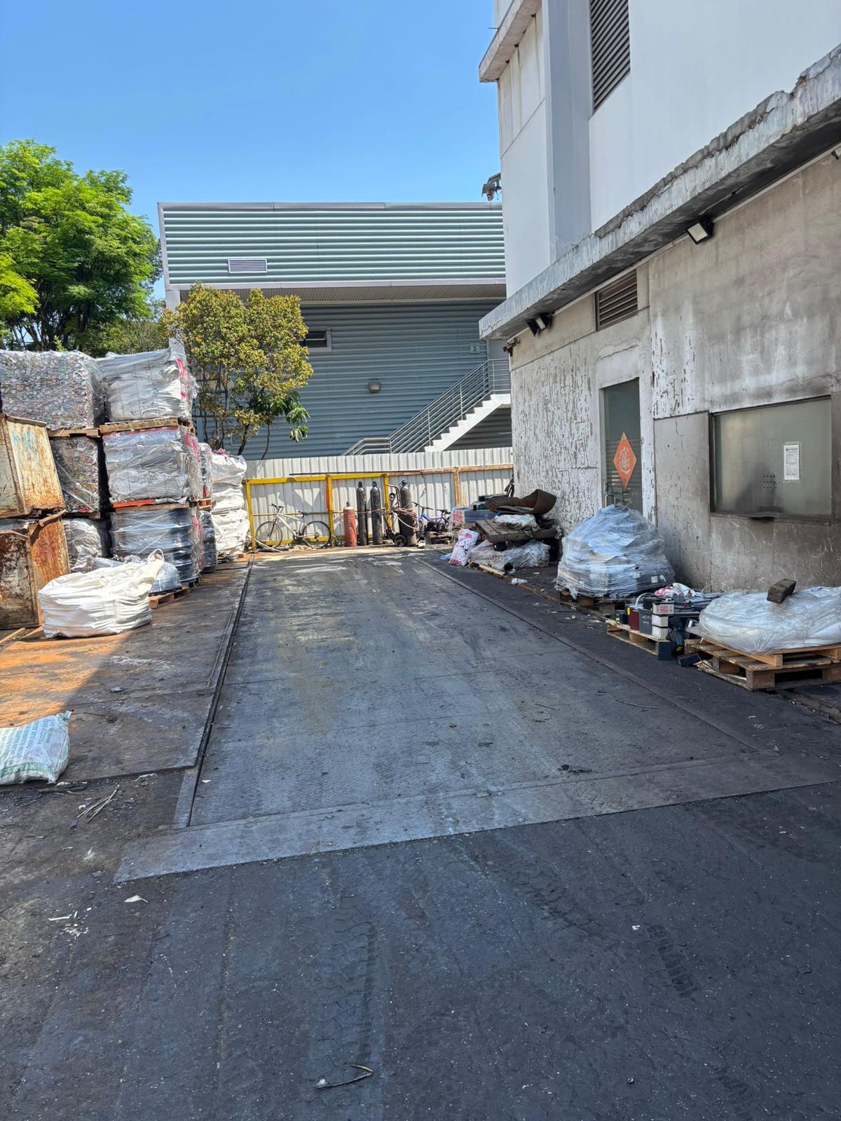 The lorry weighbridge at the Ogoo Recycle yard in Tuas, with baled and bagged metal stacked alongside
